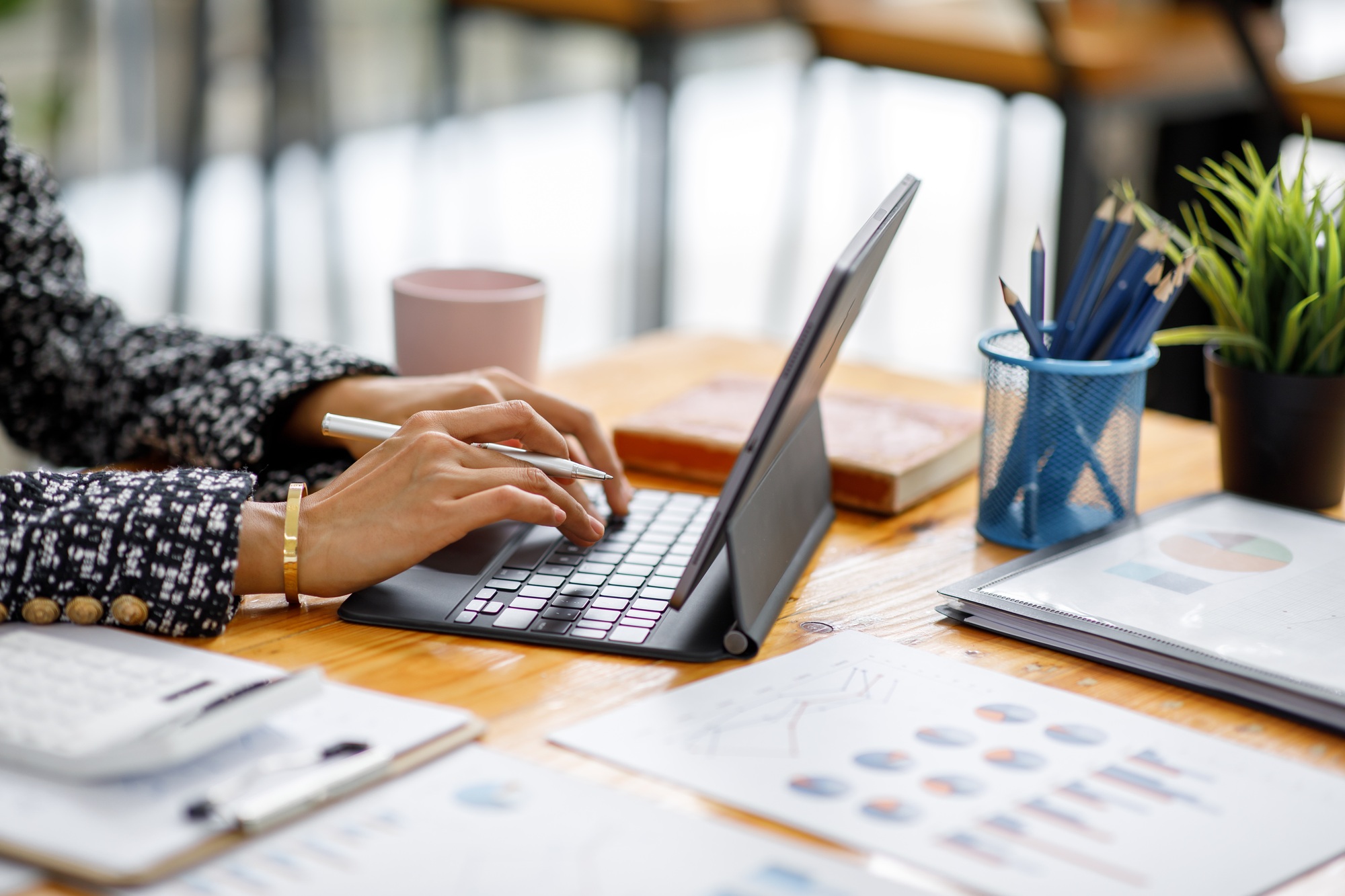 Asian Businesswoman Using laptop computer and working at office with calculator document on desk, do